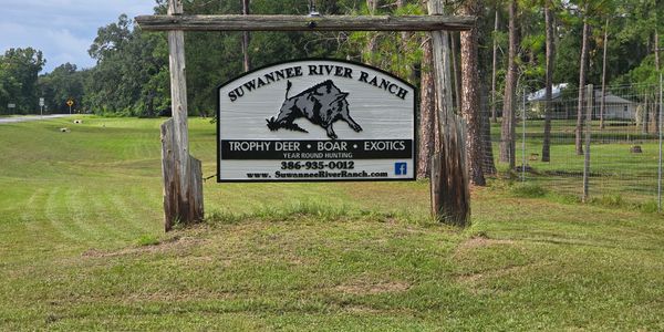 Wooden sign for Suwannee River Ranch advertising hunting opportunities.