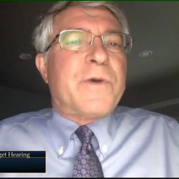 Man speaking in a video call or hearing.