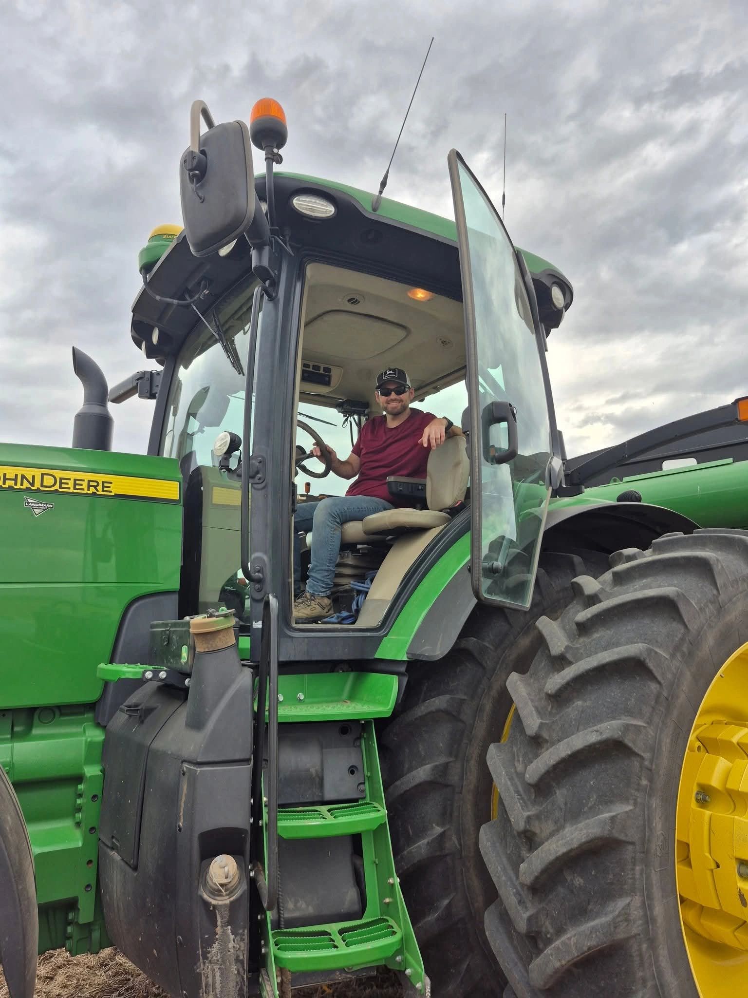 Smiling man in a tractor cabin.