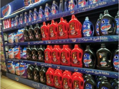 Shelf of laundry detergent bottles in different colors.