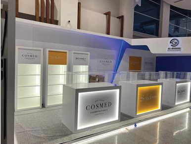 Modern COSMED cosmetic products booth at exhibition.