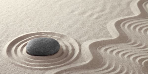 Pebble in sand with zen markings, symbolic of Jungian Psychology and value of understanding dreams