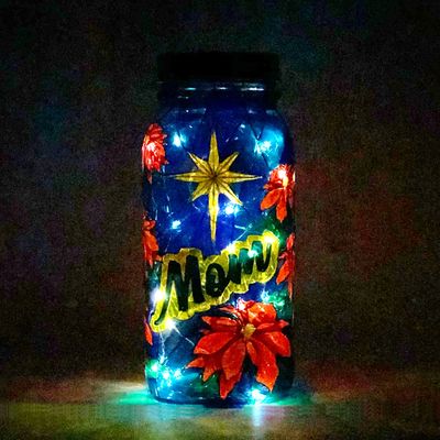 Solar light made from mason jar with poinsettias on a blue background