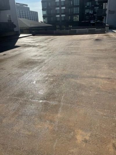 Empty rooftop parking area with buildings in the background.