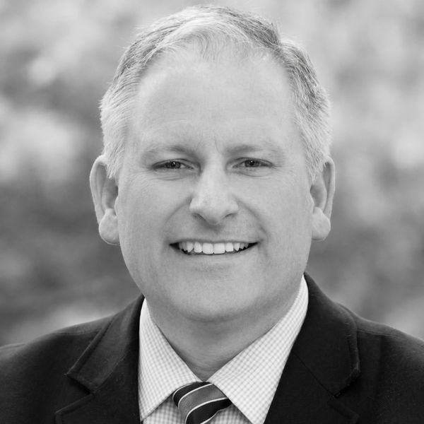 Smiling man in suit and tie.