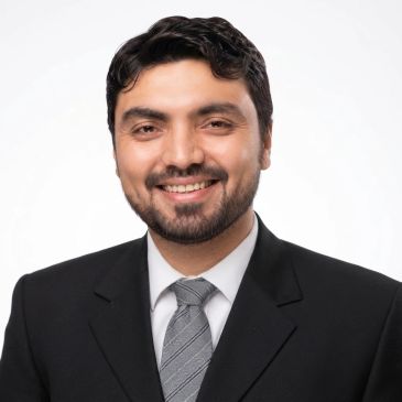 Man smiling in a suit and tie.