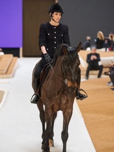Model riding horse in fashion show.