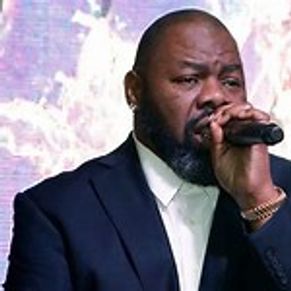 Man in suit singing into a microphone.