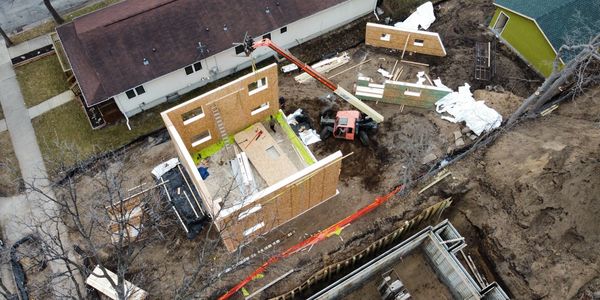Birdseye view image of a passive house's walls being installed panel by panel. 
