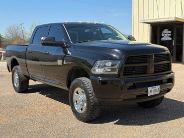 Black Dodge Ram pickup truck parked outdoors near a building.