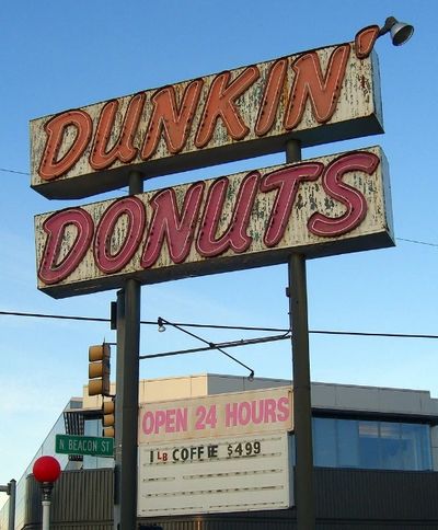 Vintage Dunkin Donuts sign advertising $4.99 coffee, open 24 hours.