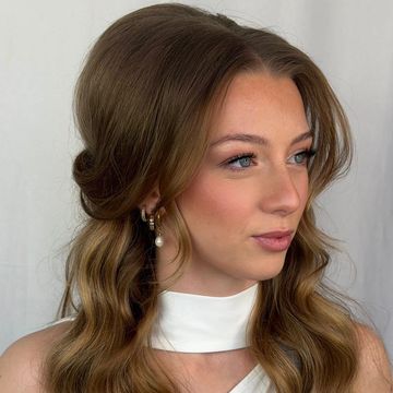 Young woman with soft curls and elegant earrings.