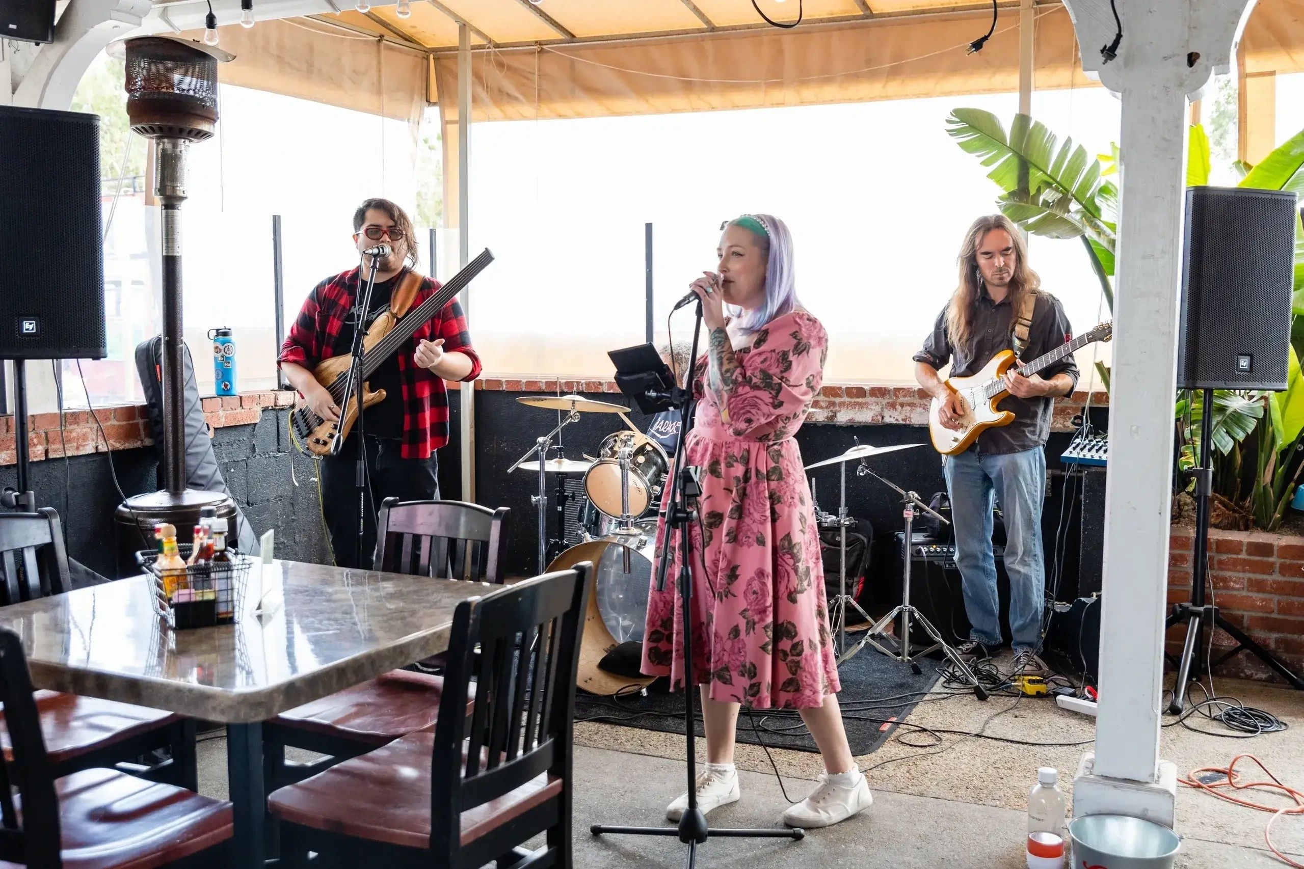 a woman singing and two men are playing guitar 
