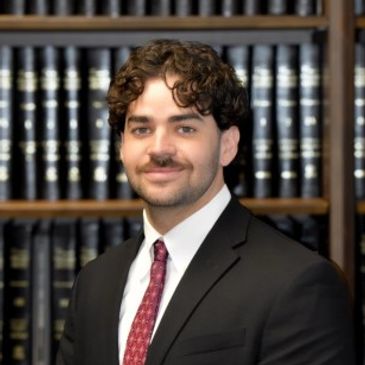 Young man in suit with bookshelves background.