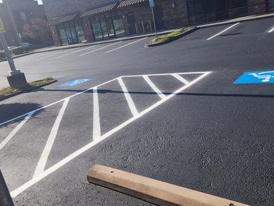 Parking lot with fresh sealcoating, asphalt crack repair and new line striping.