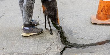 Person performing asphalt crack repair