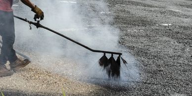 Person sealcoating a parking lot