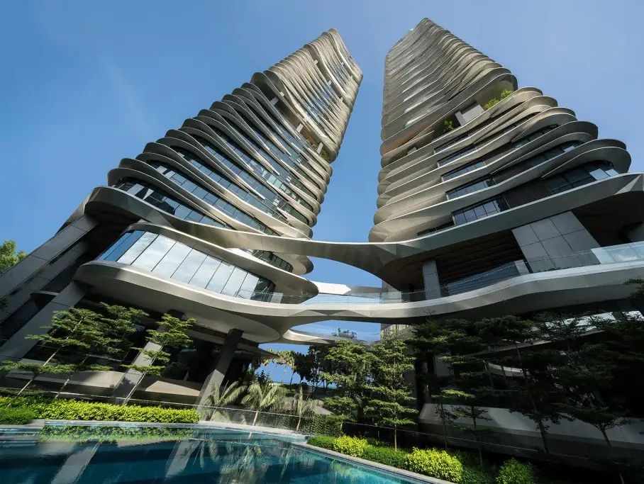 Modern twin towers with unique curved design and connecting bridges.