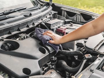 Car Detailing engine bay being wiped down and cleaned 