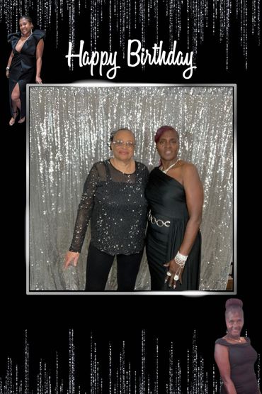 Two elegantly dressed women posing against a shimmering silver backdrop for a birthday celebration.
