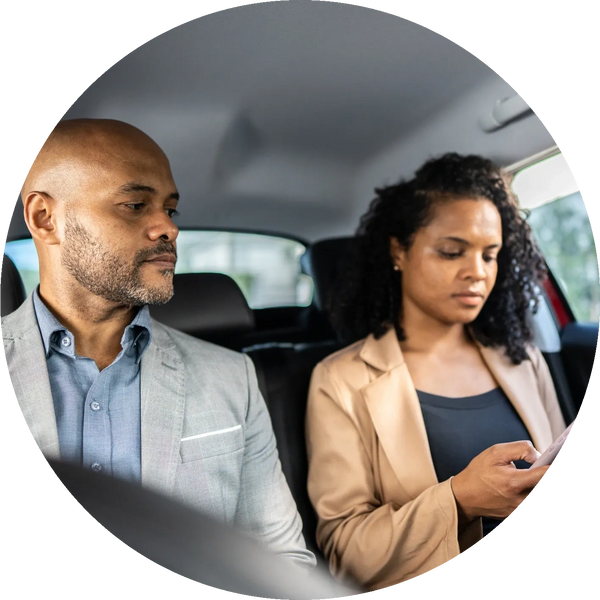 Business professionals are riding in the back seat of Press 4 Time Transportation to their location!