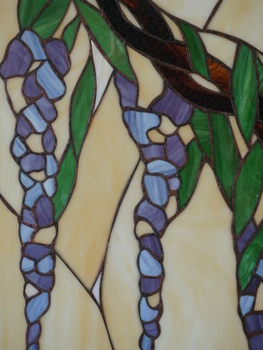 Stained glass artwork depicting purple flowers with green leaves.