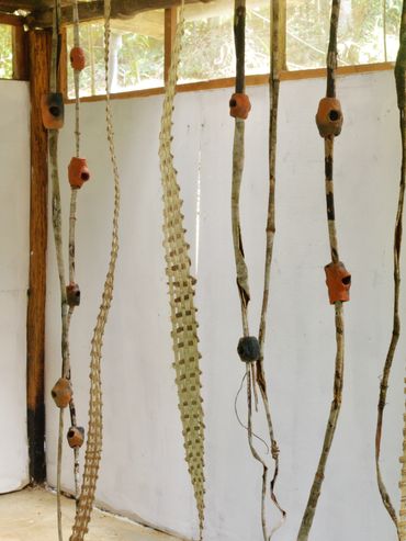Various hanging natural objects including bones and branches inside a rustic room.