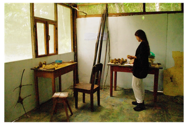 A person working with clay in a rustic art studio.