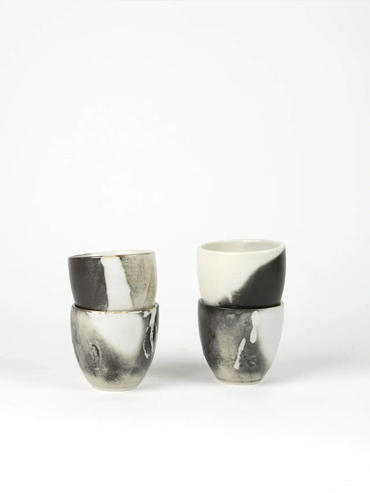Four black and white ceramic cups arranged in two stacks.