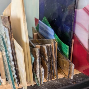 Pieces of multi-colored art glass arranged on a table top.