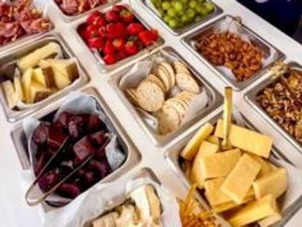 Mobile charcutterie cart filled with fresh meats, cheeses, fruit, Olives and more .
