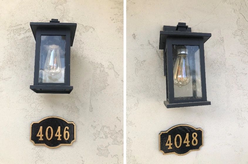Two black outdoor wall lanterns with house numbers 4046 and 4048 on a beige wall.