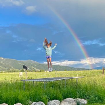 Child on Trampoline Vast Fields Outdoor Mountains Free