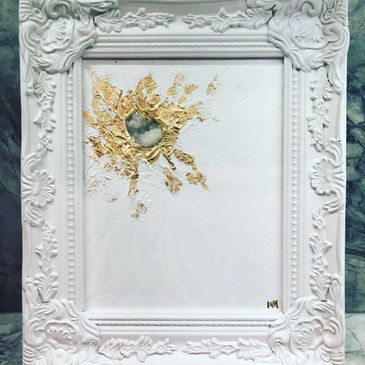 Elegant white frame with textured gold and stone centerpiece artwork.