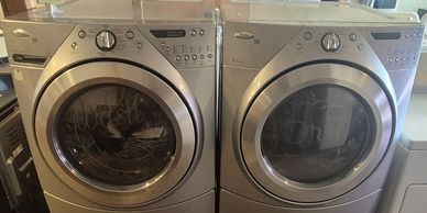 A pair of silver front-loading Whirlpool washer and dryer units.