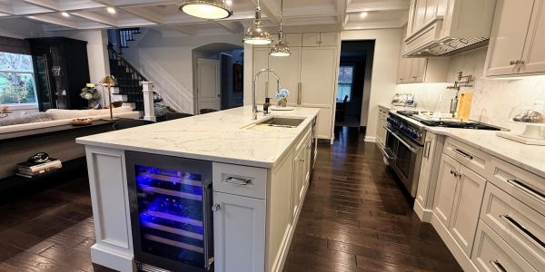 Modern kitchen with marble island and wine cooler.