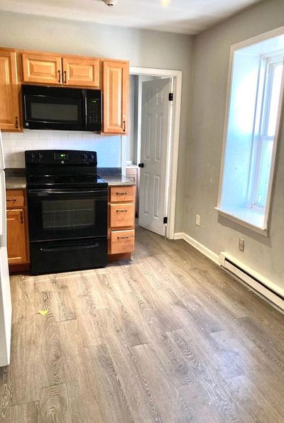 Modern kitchen with black appliances and wooden cabinets.
