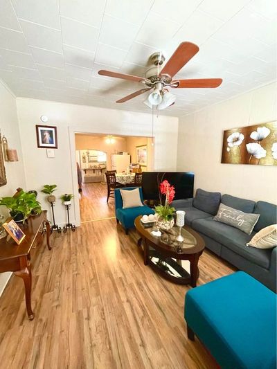Cozy living room with teal furniture and wooden flooring.