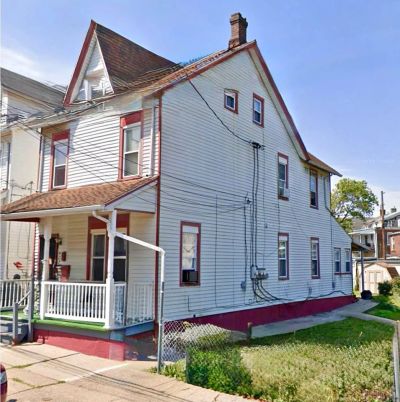 Two-story white house with red trim and a small front porch.