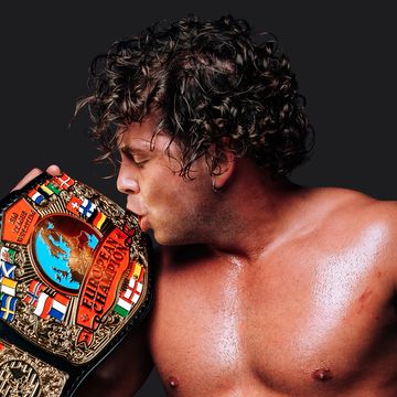 Wrestler kissing a championship belt.