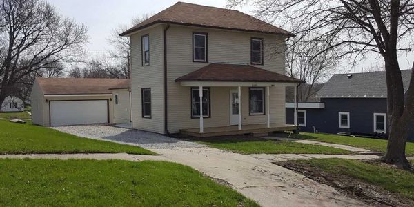 Two-story house with beige siding and a detached garage.