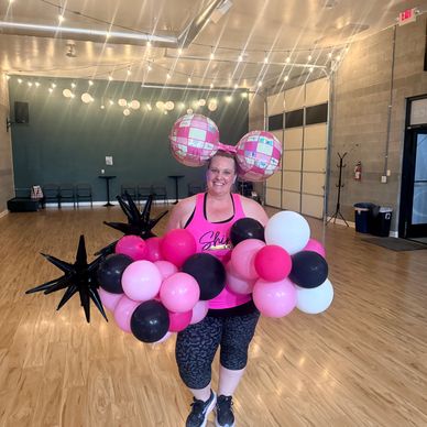 Woman with balloon decorations in a dance studio.