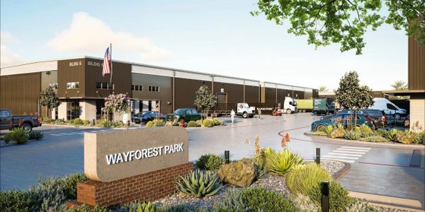 Modern industrial park with trucks and landscaped surroundings.