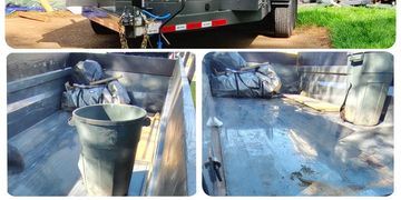 Cleaned and empty metal truck bed with a trash can and a bag.