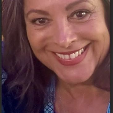 Close-up of a smiling woman with long hair.