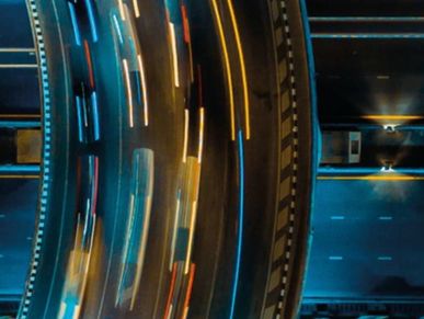 Aerial view of a curved highway with light trails from moving vehicles at night.