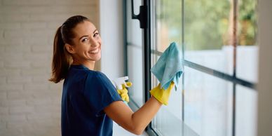 Professional cleaner wiping window with cloth – Peace of Mind Cleaning Services Winnipeg..