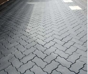 Interlocking gray stone pavers arranged in a zigzag pattern on the ground.