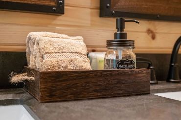 Wooden tray with bath soap and cloths on a bathroom counter.