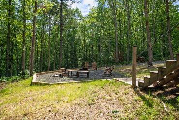 Outdoor seating area in a wooded backyard.